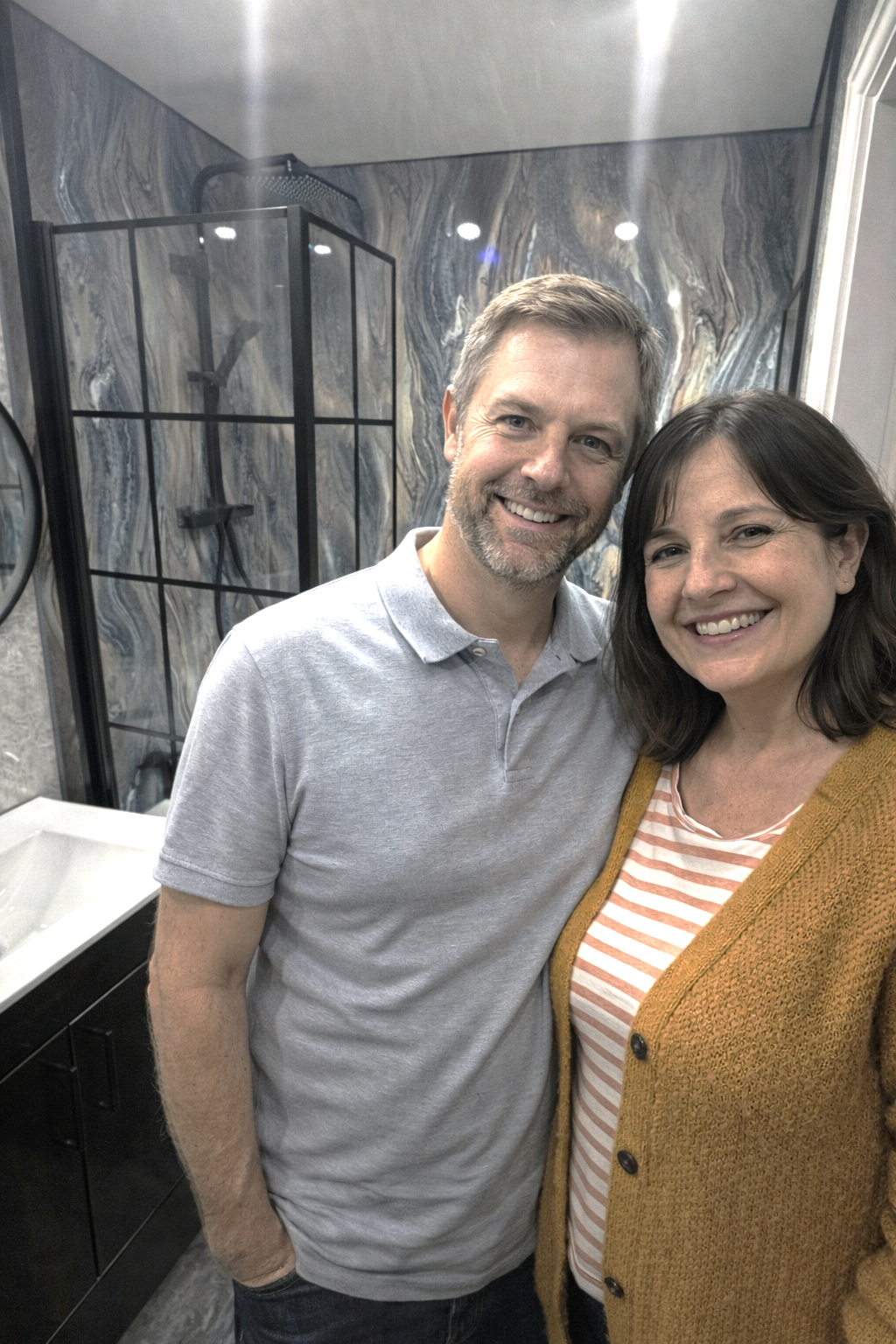 Happy couple after completing modern bathroom renovation.